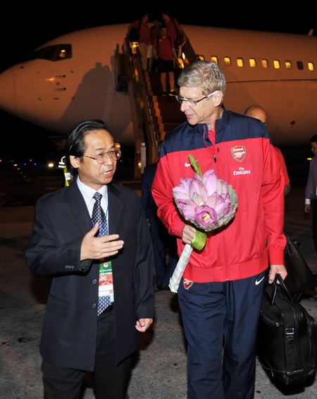 Phó chủ tịch VFF Nguyễn Lân Trung trao đổi với HLV Arsene Wenger tại sân bay Nội Bài - Ảnh: Quang Thắng (Thanh Niên)